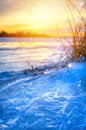 winter landscape panorama; sunset on the bank of a frozen river; ice and snow Royalty Free Stock Photo