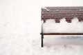 Winter landscape: park bench covered with snow Royalty Free Stock Photo