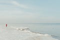 Winter landscape of a person in coat walking by the sea in Jurmala, Latvia