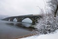 Winter landscape photo. Metrosubway bridge across the Dnipro River at foggy morning. Snow covers tree`s brunches and ground