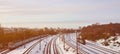 Winter landscape with a railway train on a railway surrounded by a city panorama with lots of houses and buildings against a clou