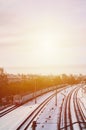 Winter landscape with a railway train on a railway surrounded by a city panorama with lots of houses and buildings against a clou