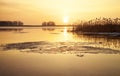 Winter landscape with river, reeds and sunset sky.