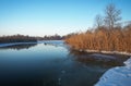 Winter landscape with river, reeds and trees.