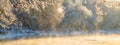 Winter landscape. River view near forest. Snow and frost at Misty sunrise