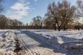 Winter landscape of the road, church and street lamp on background of blue sky.