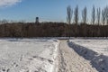 Winter landscape of the road, church and street lamp on background of blue sky.