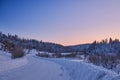 Winter landscape. Road through the evening snowy forest. At the edges, spruce and birch are covered with snow. Western Royalty Free Stock Photo