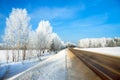 Winter landscape with the road the forest and the blue sky Royalty Free Stock Photo