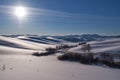 Winter landscape with road and heels under snow with Sun on blue sky Royalty Free Stock Photo