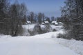 Winter landscape with road leading to village houses with snow covered roofs Royalty Free Stock Photo