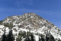 Winter Landscape of Rocky Summit Peak Covered in Powder Snow Above Mountain Forest