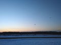 Winter landscape in silhouette of a skydiver with a parachute at sunset Royalty Free Stock Photo