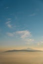 Winter landscape with snow capped mountain peak under sunlight and blue sky with clouds Royalty Free Stock Photo