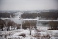 Winter landscape of snow-covered fields, trees and river in the early misty morning. Royalty Free Stock Photo
