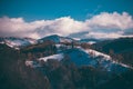 Winter landscape with snow-covered hills and mountains. Human settlements in wild areas