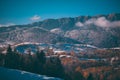 Winter landscape with snow-covered hills and mountains. Human settlements in wild areas