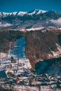 Winter landscape with snow-covered hills and mountains. Human settlements in wild areas