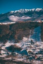 Winter landscape with snow-covered hills and mountains. Human settlements in wild areas