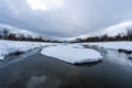 Winter landscape with snow covered lake and forest and mountains in the background. Royalty Free Stock Photo