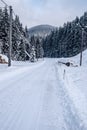 winter landscape with snow covered road, forest and hill on the background in Beskids mountains Royalty Free Stock Photo