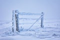 Winter landscape of a snow-covered wooden gate in a field Royalty Free Stock Photo