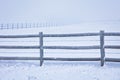 Winter landscape of a snow-covered wooden gate in a field Royalty Free Stock Photo