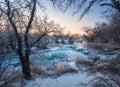 Winter landscape with snowy trees, beautiful frozen river at sun Royalty Free Stock Photo