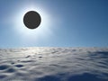 Winter landscape with solar eclipse above the snowy desert