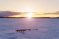 Winter landscape, winter sports. silhouettes of fishermen on a winter lake at sunset fishing. Royalty Free Stock Photo