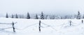 Winter landscape in the Sudetes, white snow covers the field and the forest surrounded by a fence Royalty Free Stock Photo