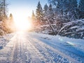 Winter landscape with sunbeams, forest and road Royalty Free Stock Photo