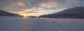 Winter landscape, sunset over snowy forest and frozen lake in Lapland. Trees covered with snow in the sun. Royalty Free Stock Photo