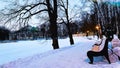 Winter landscape with trail in snowy winter park and wooden benches with view on frozen lake and palace. Travel Saint Royalty Free Stock Photo