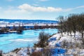 Winter landscape with trees on a hill by the river Royalty Free Stock Photo