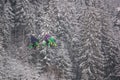 Winter landscape - view of the bike zip line with cyclists above the winter mountain forest during a snowfall, Bukovel ski resort,