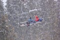 Winter landscape - view of the chairlift lift with skiers in the winter mountain forest during a snowfall, Bukovel ski resort, Car