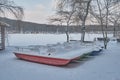 A view of the snow-covered colored pedal boats, the frozen lake and the city beach Royalty Free Stock Photo
