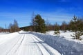 Winter landscape. View of snow-covered trees, snowdrifts and road in the countryside in winter on a frosty Sunny day. Russian Royalty Free Stock Photo