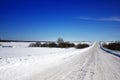 Winter landscape. View of snow-covered trees, snowdrifts and road in the countryside in winter on a frosty Sunny day. Russian Royalty Free Stock Photo