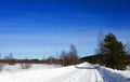 Winter landscape. View of snow-covered trees, snowdrifts and road in the countryside in winter on a frosty Sunny day. Russian Royalty Free Stock Photo