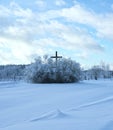 Winter landscape of village with wooden cross by the road