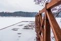 Winter Landscape with Wooden Fishing Bridge on Frozen Lake Shore Royalty Free Stock Photo