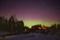 Winter landscape with wooden house under a beautiful starry sky and Northern Lights Royalty Free Stock Photo