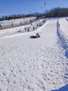 Winter, leisure, sport, and people concept - happy teenage girl or woman sliding down on snow tube over mountain background