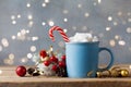 Winter lifestyle with cup of hot cocoa with marshmallows and Christmas decoration on wooden background. Bokeh effect