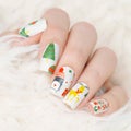 Winter manicure with Christmas tree pattern, gift and deer