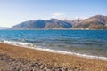 Winter Mediterranean landscape on calm sunny day. Sea, snow-crowned mountains and deserted pebble beach. Montenegro, Bay of Kotor Royalty Free Stock Photo