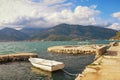 Winter Mediterranean landscape with one white boat in small harbor. Montenegro