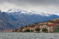 Winter Mediterranean landscape on cloudy day. Montenegro. View of Bay of Kotor, Prcanj town and snow-capped mountain of Lovcen